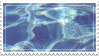 an unmoving stamp of a closeup shot of a body of water. the water is clean and likely in a pool. there is a lot of light reflecting off of its surface.